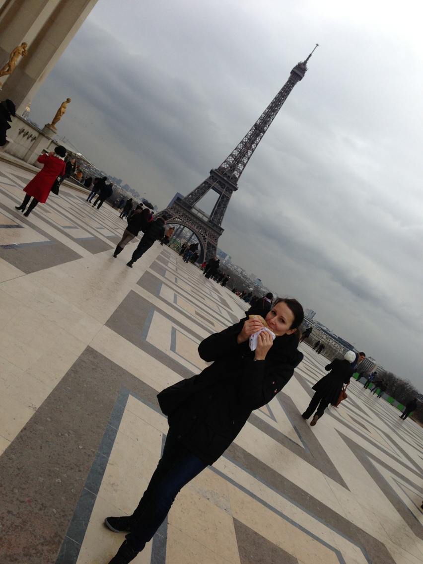 alt="Frau isst Crêpe am Place du Trocadéro in Paris"