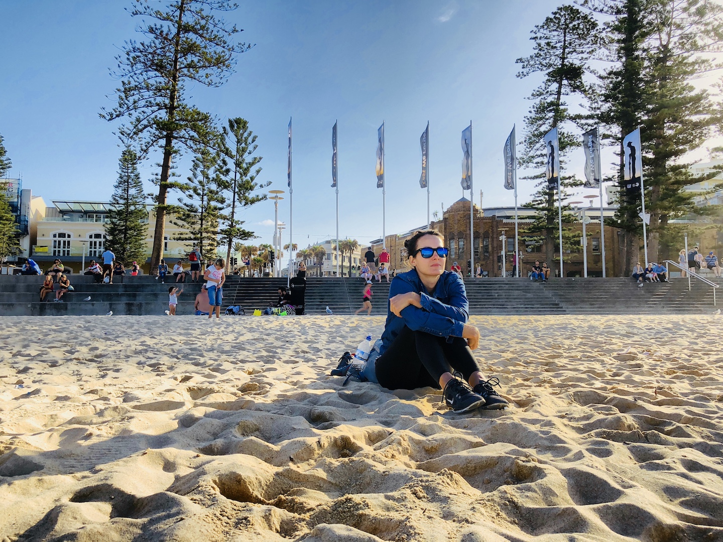 Frau sitzt am Manly Beach in Sydney